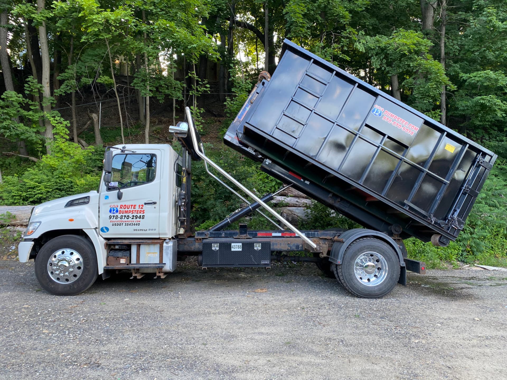 Route 12 truck tilting a dumpster for unloading