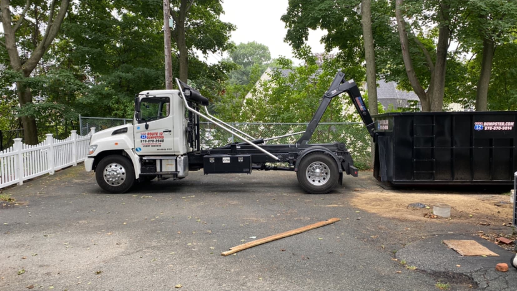 Route 12 truck delivering a dumpster to a driveway